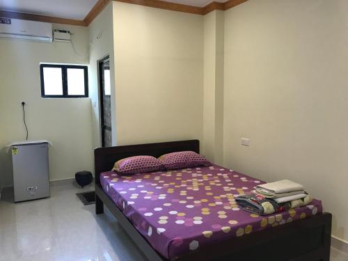 瓦斯科达伽马All Seasons Guest House的一间卧室配有一张带紫色床单和枕头的床。