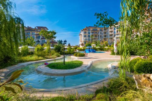 内塞伯尔Poseidon VIP Residence Club Balneo & SPA Resort的公园内一座游泳池,有建筑背景