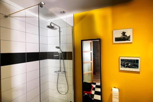 阿尔布瓦Maison des Orfèvres的带淋浴的浴室和黄色墙壁