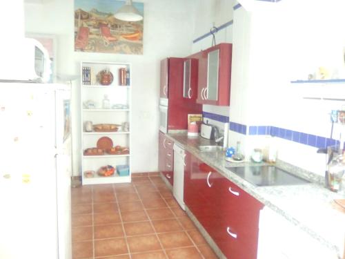 阿亚蒙特El Mirador de la Desembocadura的厨房配有红色橱柜和白色冰箱