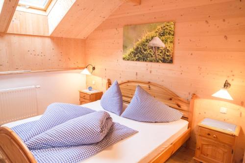 ScheibbsUrlaub mitten im Wald - Lueg的一间卧室配有一张带蓝色和白色枕头的床