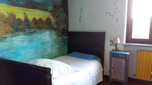 博尔戈马内罗Il Nido del Pettirosso的卧室内的一张床铺,墙上有绘画作品
