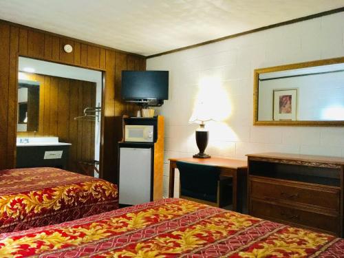 卡尔卡斯卡卡尔卡斯卡 - 格拉纳达汽车旅馆的酒店客房设有两张床、一张桌子和一台电视。