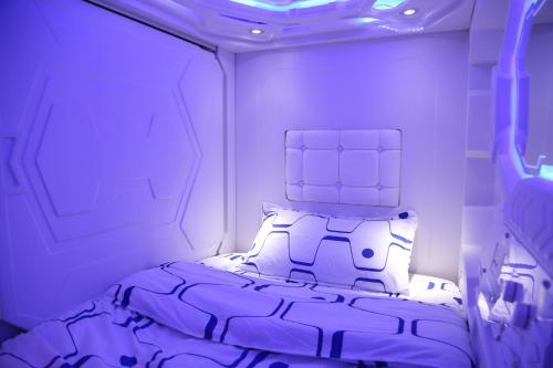 马尼拉Dormitos的一间紫色照明客房内的一张床卧室
