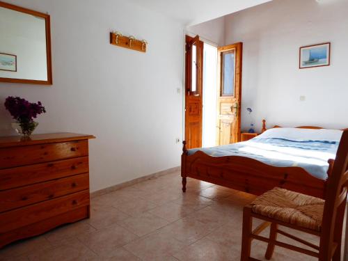 哈尔基岛Villa Yorgos的一间卧室配有一张床、一个梳妆台和一扇窗户。