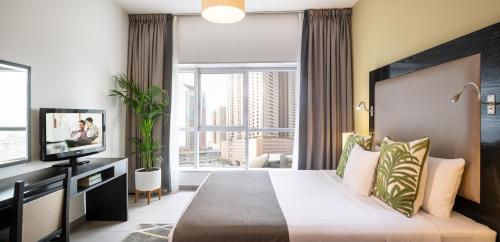 迪拜Citadines Metro Central Hotel Apartments的酒店客房设有一张床和一个大窗户