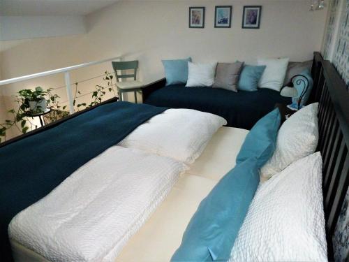 GerbrunnSchedler 2的一间卧室配有两张带白色和蓝色床单的床