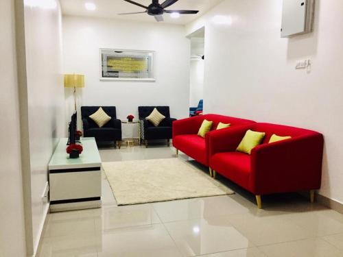 JertihAisya homestay jerteh的客厅配有红色的沙发和桌子