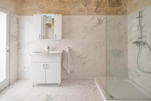 萨奈特Girgentina Farmhouse的白色的浴室设有水槽和淋浴。