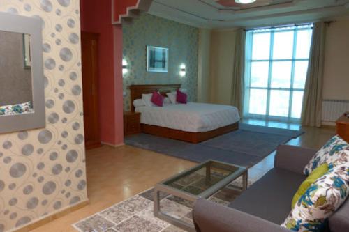 奥兰MARAVAL的一间卧室配有一张床,客厅配有沙发