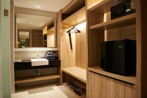 高兰Moonlight Bed & Brunch - SHA Extra Plus的浴室设有水槽和电视。