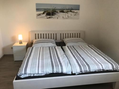 LassanHaus-Hafenblick的一间卧室配有带条纹被子的床
