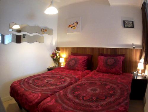 鹿特丹义曼哥尼住宿加早餐旅馆的一间卧室配有红色枕头和一张红色大床
