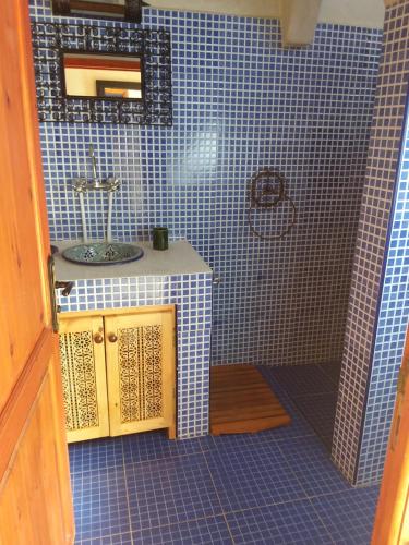 提兹尼特Maison du Soleil的浴室配有水槽和蓝色瓷砖墙。
