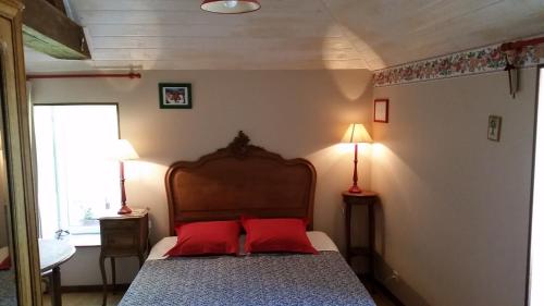 Vaux-sur-Aure科特康帕涅酒店的一间卧室配有一张带两个红色枕头的床