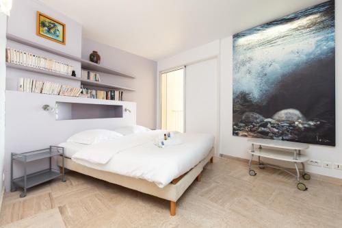 戛纳Mer du Sud 4 YourHostHelper的卧室配有一张床,墙上挂着一幅大画