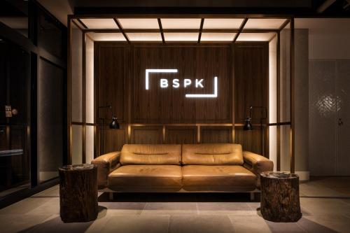 东京Bespoke Hotel Shinjuku的墙上有标志的真皮沙发