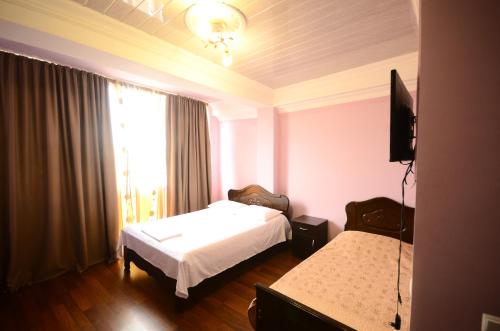 巴统Hotel Peria的酒店客房设有两张床和窗户。