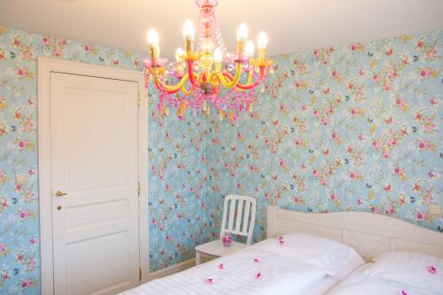 博尔赫隆'Hof der Heerlijckheid'的一间卧室配有吊灯和花卉壁纸