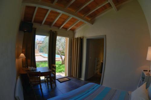蒙塔尼亚克罗里维特旅馆的一间卧室配有一张床、一张书桌和一个窗户。