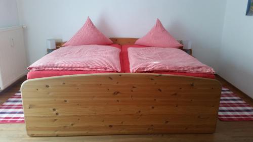 罗滕布Martina's place的一张带两个粉红色枕头的木床