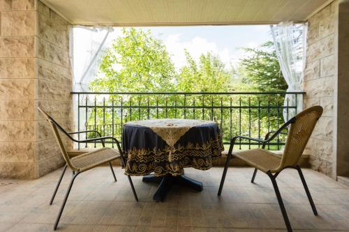 Al MţullahMresty Guest House的阳台配有桌椅和窗户