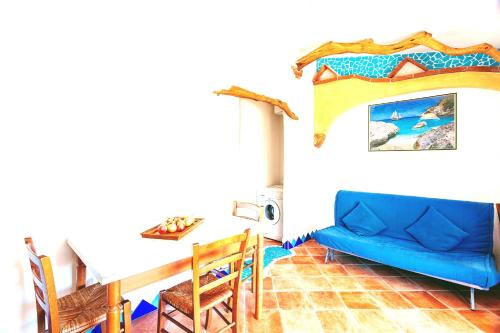 奥罗塞伊Orosei RE - Il Paradiso degli Ulivi con vista mare的客厅配有蓝色的沙发和桌子