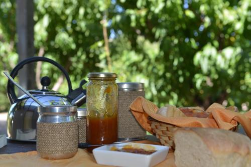 圣拉斐尔Casita Rural Los Abuelos的桌子,带面包和果酱,茶壶