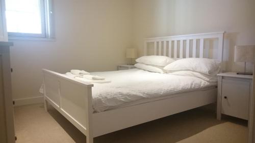 怀特黑Harbourside Apartment的白色的床、白色床单和枕头