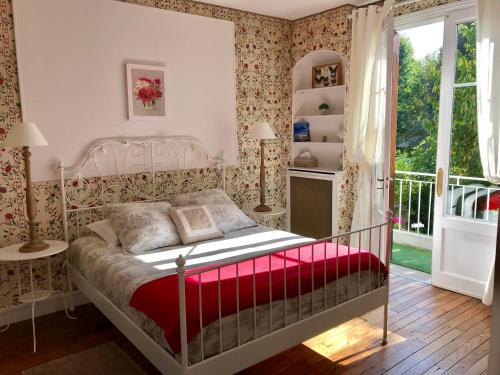 罗什科尔邦卢瓦尔河谷中世纪度假屋的一间卧室配有一张带红色毯子的床