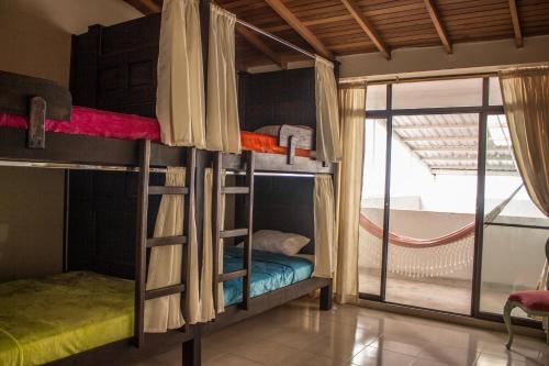 佩雷拉Casa Azul Boutique Hostel的客房设有两张双层床和窗户。