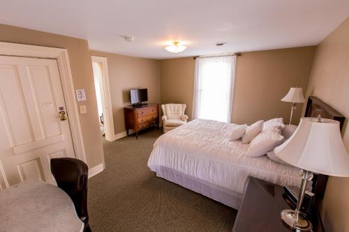 伊利Victoria Inn的卧室配有床、椅子和窗户。