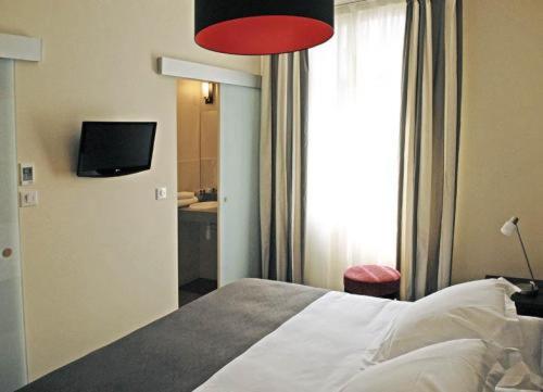 图尔龙萨酒店的一间卧室配有一张红灯床和一台电视