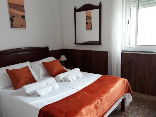 奥德赛克斯Casa Dorita的一间卧室配有一张带橙色和白色枕头的大床