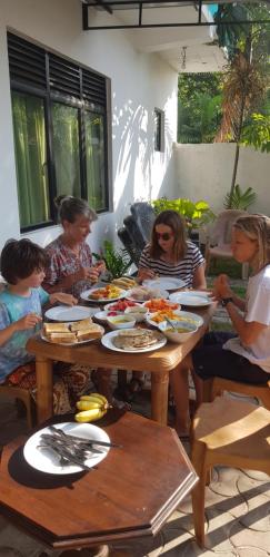 马特勒Polhena Coral Reef Resort的一群坐在餐桌上吃食物的人