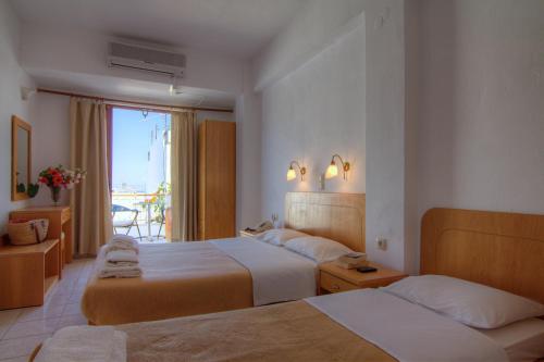 圣加利尼阿多尼斯酒店的酒店客房设有两张床和窗户。