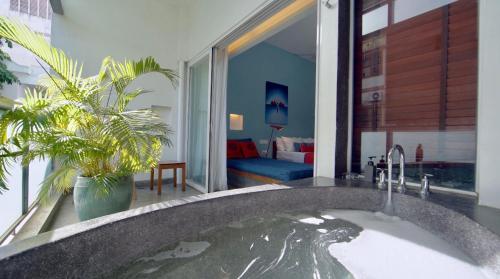 金边红毛丹酒店 - 金边的浴室配有带水的大浴缸