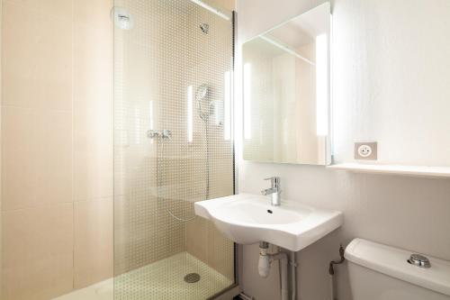 珀套特科姆博特B&B HOTEL Pontault Combault的浴室配有盥洗盆和带镜子的淋浴