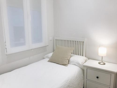 马德里Reina Victoria 46的白色的卧室设有床和窗户