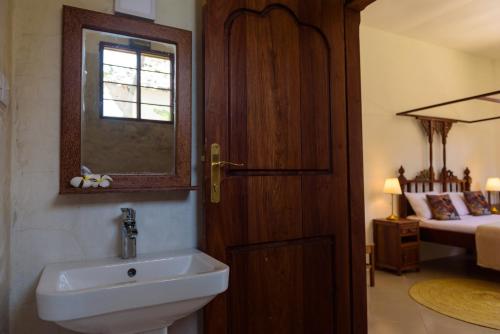吉汶瓦Magic Beach Villa的一间带水槽、窗户和床的浴室