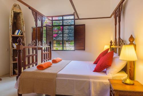 吉汶瓦Magic Beach Villa的一间卧室配有带橙色枕头的床