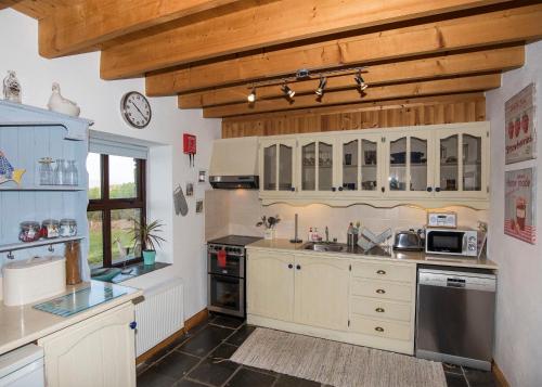 DurrusDunmanus View的厨房配有白色橱柜和木制天花板