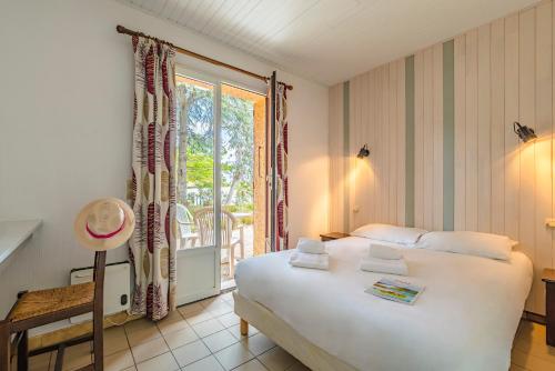 滨海阿热莱斯Azureva Argeles的卧室设有一张白色大床和一扇窗户。