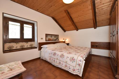 布勒伊-切尔维尼亚Maison Rosalp的一间卧室设有一张床和木制天花板