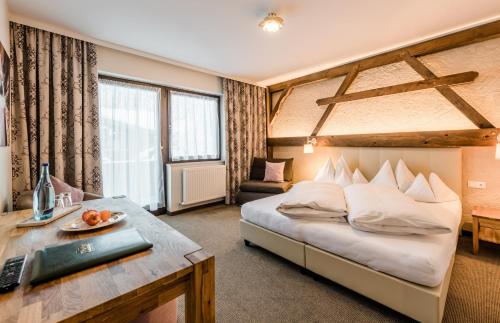 费尔兹姆斯里德尔阿尔卑斯山别墅酒店的配有一张床和一张书桌的酒店客房