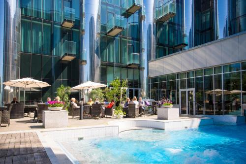 塔林多尔帕特温泉&会议酒店的一座酒店庭院,在一座建筑前设有一个游泳池