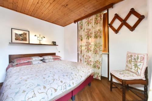 布勒伊-切尔维尼亚卡斯泰利公寓式酒店的一间卧室配有一张床和一把椅子
