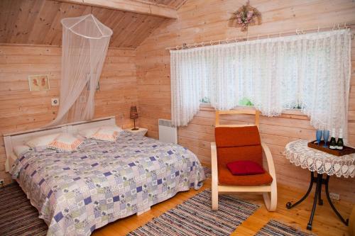 Nasva乐琶玫萨度假屋的卧室配有1张床、1张桌子和1把椅子
