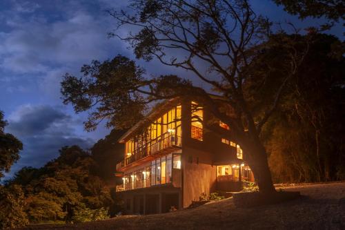 蒙泰韦尔德哥斯达黎加Koora Monteverde-a Cloud Forest Hotel by Sandglass的树在晚上点燃的房子