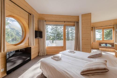 阿沃里亚兹Chalet de Prestige l'Arketa - maeva Home - maeva Home的一间卧室设有两张床和大窗户